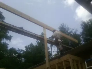 Carpenter setting a ridge beam over a new addition frame — Ice Dam Removal by Roofing Brothers in Eskridge