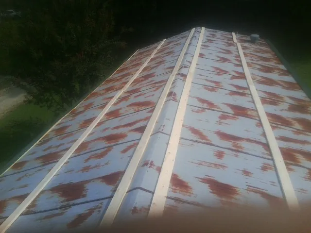 Rusted metal roof panels with new wood purlins before replacement — Storm Damage Roof Repair in Eskridge by Roofing Brothers