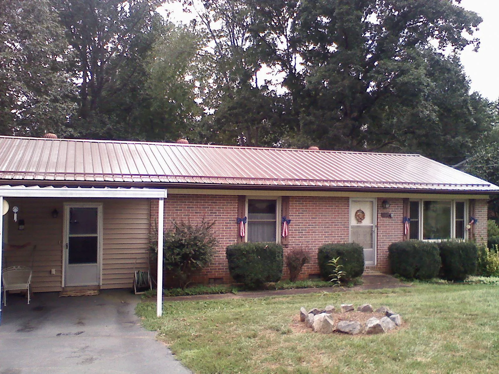 Bronze metal roof and carport on a brick ranch home — Roof Repair work by our crew in Eskridge