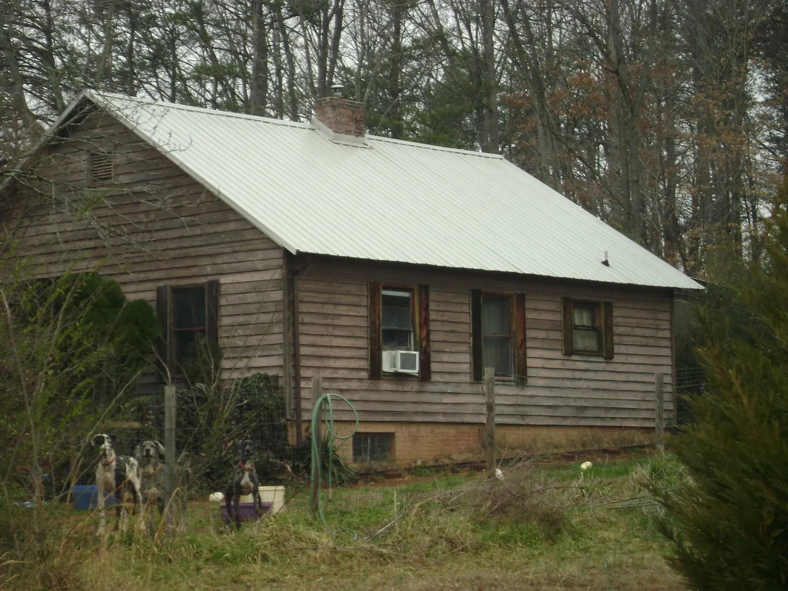 White metal roof on an old wood sided farmhouse, from a Metal Roof Installation job in Eskridge